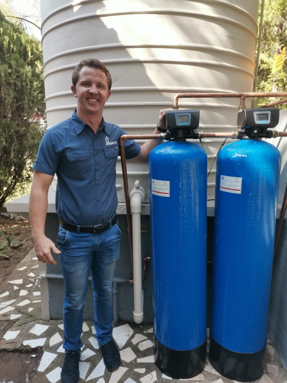 IntegriPure technician alongside a completed twin-vessel filtration installation